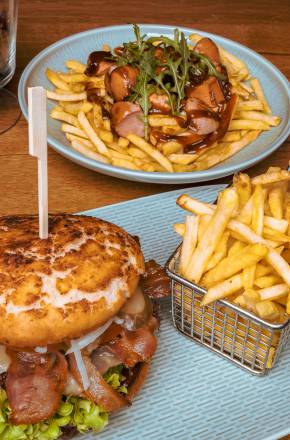 Leckerer selbst gemachter Burger mit Pommes und eine Currywurst