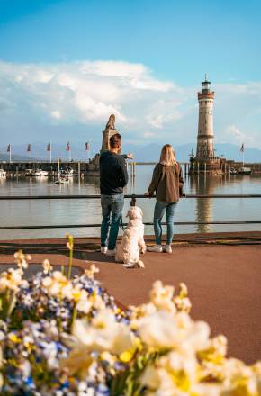 Hundebesitzer genießen den Ausblick auf den Hafen der Insel Lindau