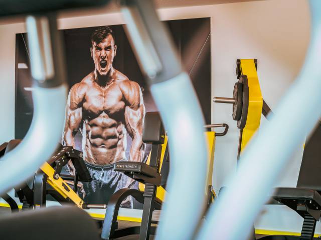 Detailaufnahme im Gym mit Bild von muskulösem Bodybilder