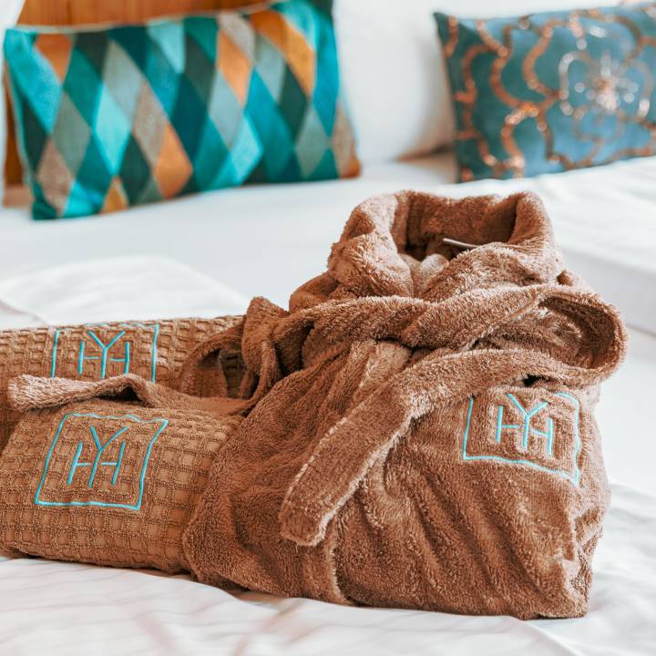 Handtücher und Bademantel auf einem Hotelbett